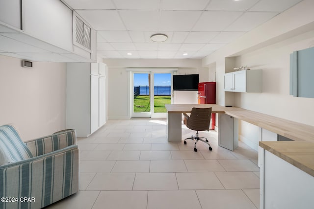 tiled office with a paneled ceiling