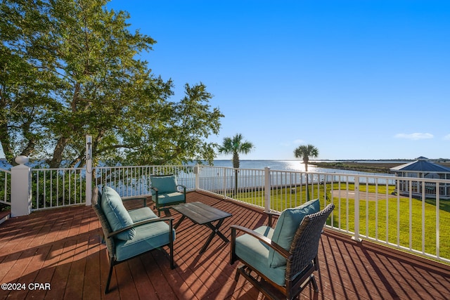 wooden terrace featuring a water view and a yard