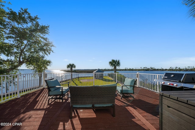 wooden deck featuring a water view, a yard, and a grill