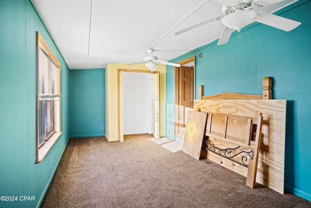 unfurnished bedroom with ceiling fan, multiple windows, and carpet