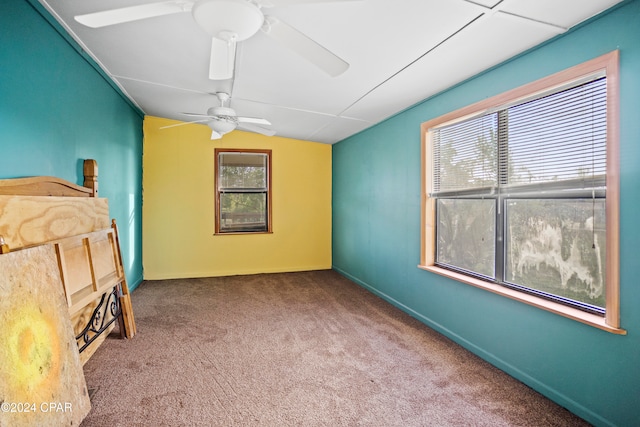 unfurnished bedroom featuring ceiling fan, carpet flooring, and vaulted ceiling