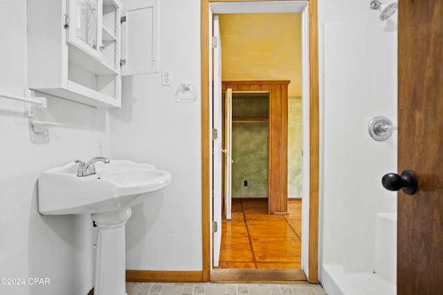 bathroom with walk in shower and wood-type flooring