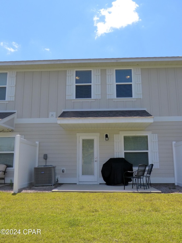 back of property with a yard, a patio area, and central air condition unit