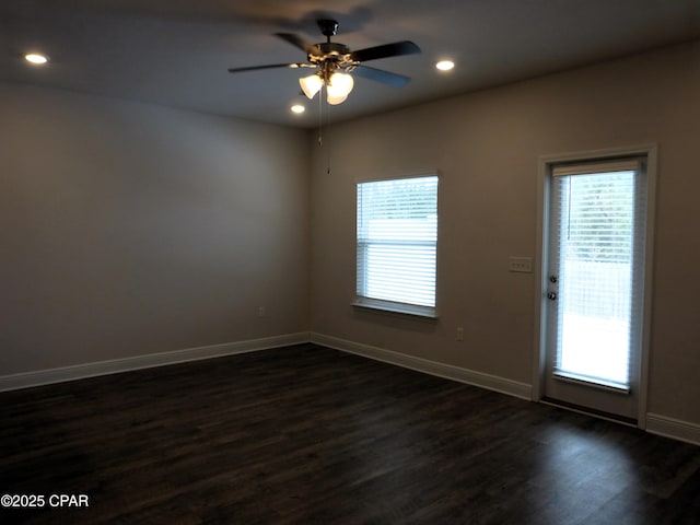 spare room with dark wood-type flooring and ceiling fan