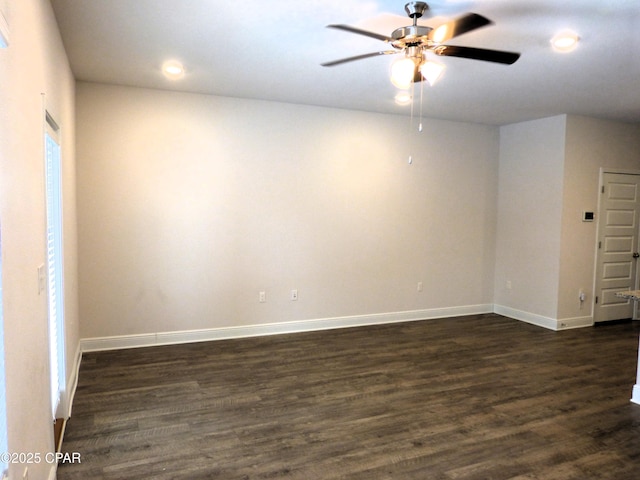 spare room featuring dark wood-type flooring and ceiling fan