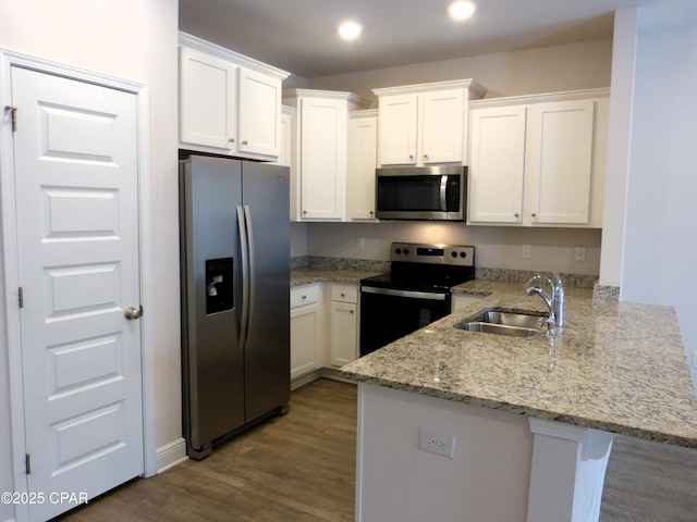 kitchen featuring white cabinetry, kitchen peninsula, and appliances with stainless steel finishes