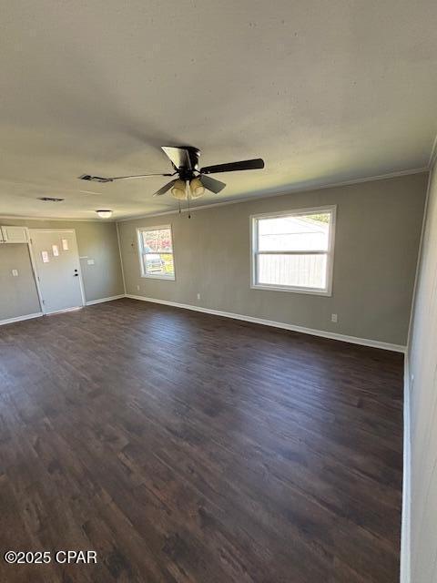 spare room with visible vents, baseboards, and dark wood-style flooring