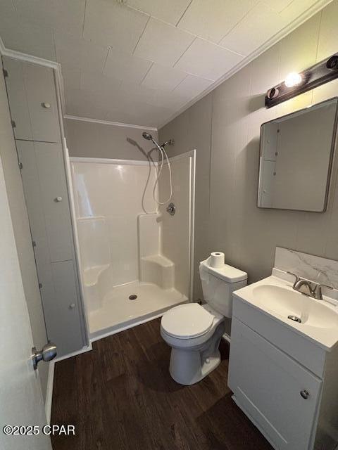 full bathroom with toilet, a stall shower, wood finished floors, and vanity