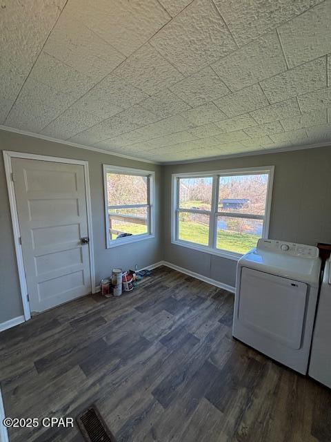 laundry room featuring dark wood-style floors, crown molding, washer / clothes dryer, laundry area, and baseboards