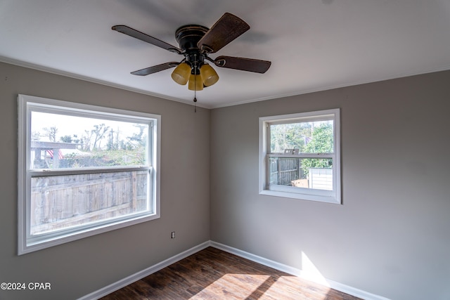 unfurnished room with baseboards, dark wood finished floors, and a ceiling fan