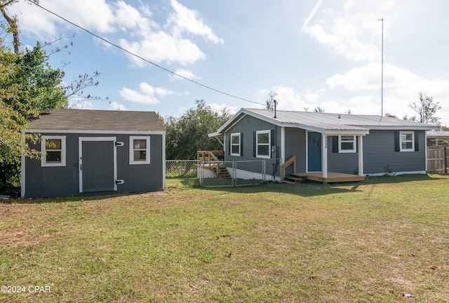 rear view of house featuring a lawn and a storage shed