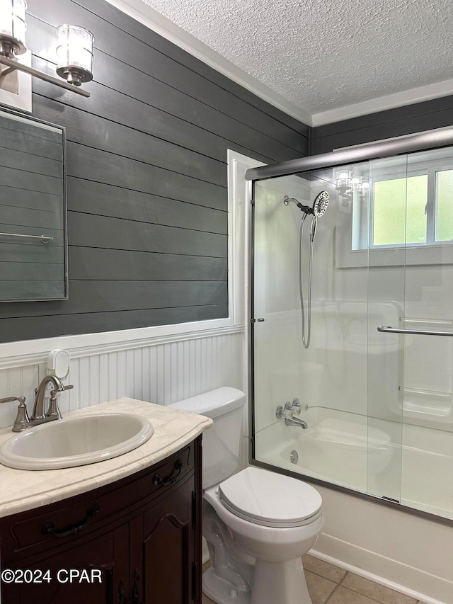 full bathroom with vanity, shower / bath combination with glass door, tile patterned floors, toilet, and a textured ceiling