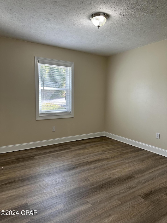 2849 Miltonia Ave, Marianna, FL 32448 - spare room with a textured ceiling, dark wood-style floors, and baseboards