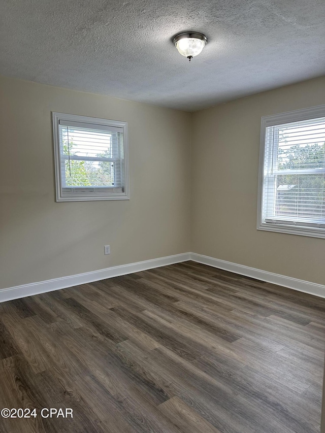 2849 Miltonia Ave, Marianna, FL 32448 - unfurnished room featuring a textured ceiling, dark wood-type flooring, and baseboards