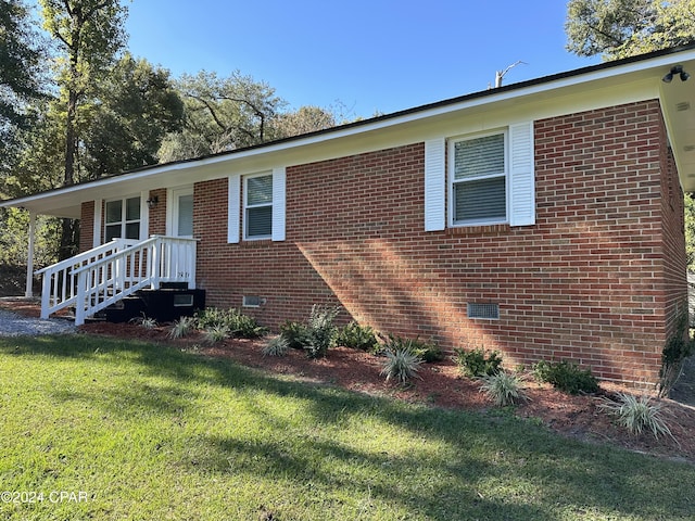 view of front of property featuring crawl space, a front lawn, and brick siding