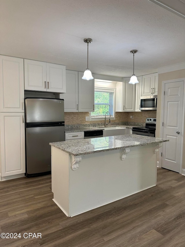 kitchen featuring pendant lighting, stainless steel appliances, and a kitchen island