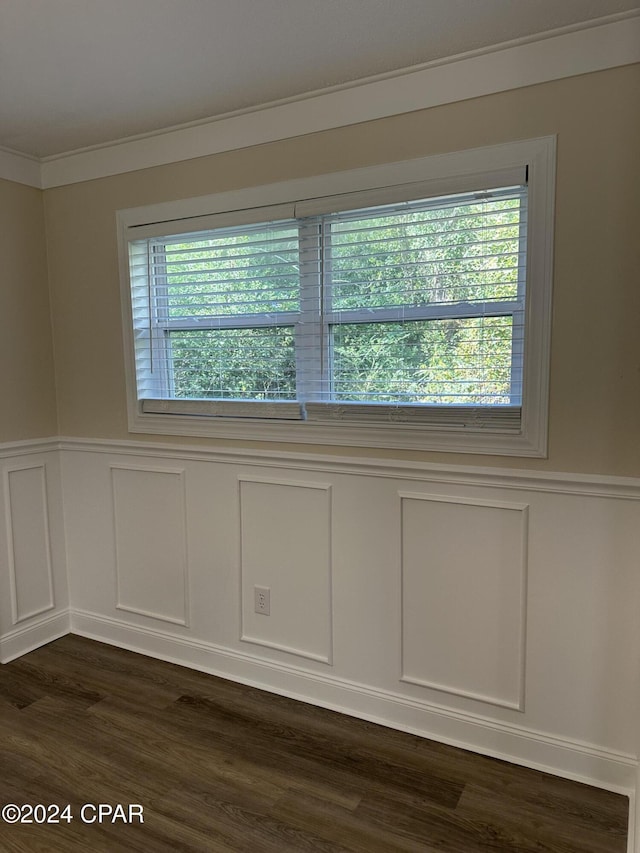 2849 Miltonia Ave, Marianna, FL 32448 - empty room with a decorative wall, ornamental molding, dark wood finished floors, and wainscoting