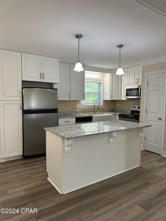 2849 Miltonia Ave, Marianna, FL 32448 - kitchen featuring stainless steel appliances, white cabinets, dark wood finished floors, decorative backsplash, and ornamental molding