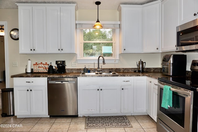 kitchen featuring stainless steel appliances, a textured ceiling, sink, light tile patterned floors, and white cabinetry