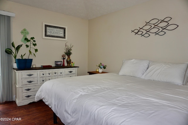 bedroom with dark hardwood / wood-style flooring and a textured ceiling