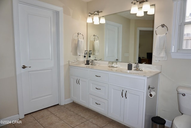 bathroom with toilet, vanity, and tile patterned flooring