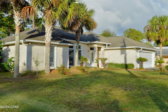 view of front of home with a front lawn and a garage