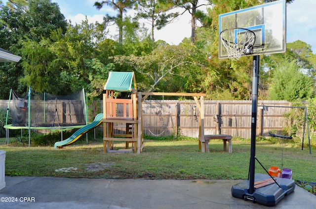 view of play area with a trampoline and a lawn