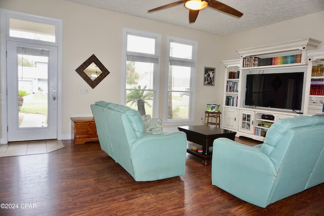 living room with dark hardwood / wood-style flooring, a textured ceiling, and ceiling fan