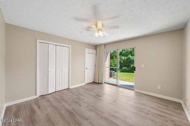 unfurnished bedroom featuring access to exterior, light wood-type flooring, a textured ceiling, and ceiling fan