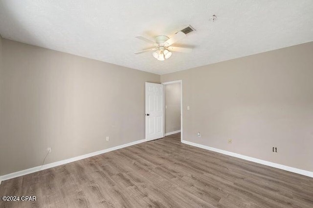 unfurnished room featuring hardwood / wood-style floors, ceiling fan, and a textured ceiling