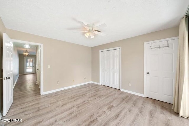 unfurnished bedroom with a textured ceiling, light hardwood / wood-style floors, and ceiling fan