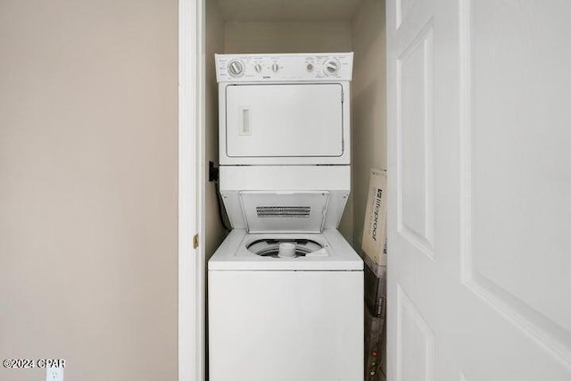 clothes washing area featuring stacked washer / dryer