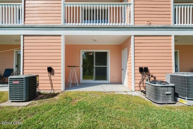 back of house featuring central AC unit, a yard, and a balcony