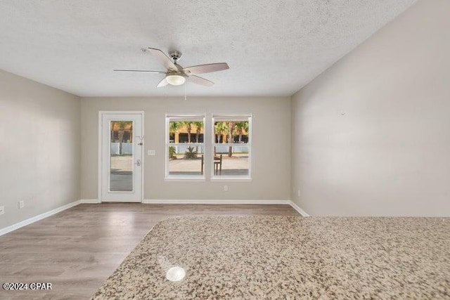 empty room featuring a textured ceiling, hardwood / wood-style flooring, and ceiling fan