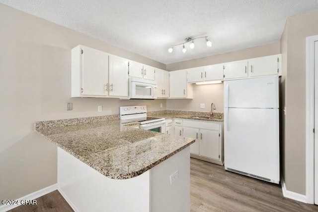 kitchen with white cabinetry, white appliances, light stone counters, and light hardwood / wood-style flooring