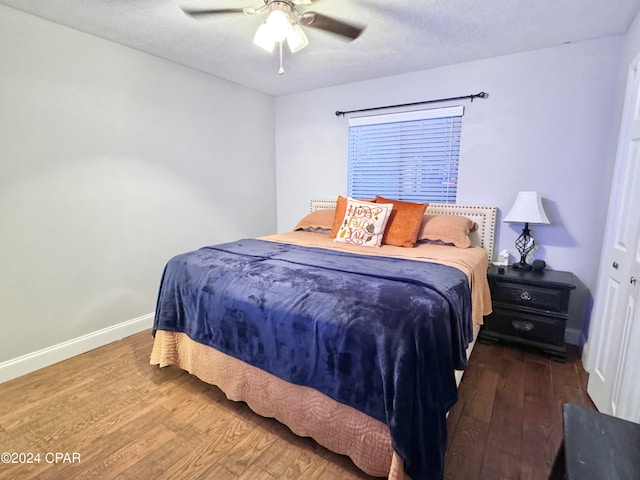 bedroom featuring ceiling fan, wood-type flooring, a textured ceiling, and a closet