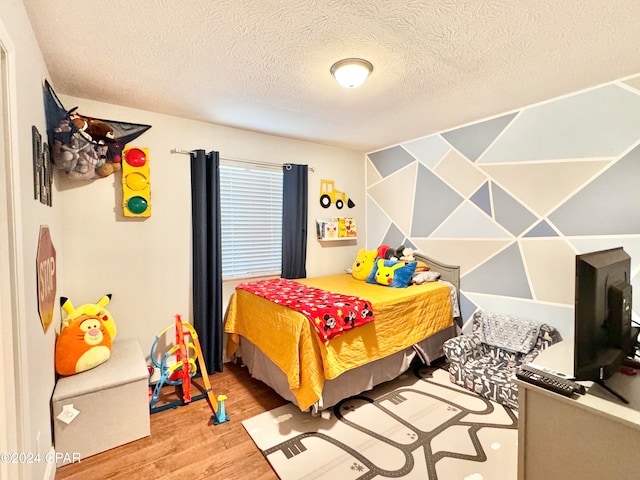 bedroom featuring wood-type flooring and a textured ceiling