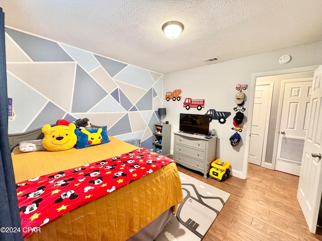 bedroom featuring a textured ceiling and hardwood / wood-style flooring