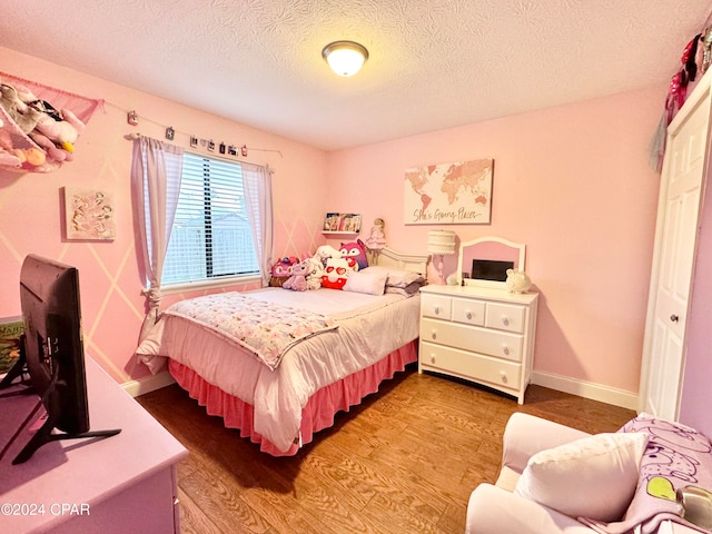 bedroom featuring hardwood / wood-style floors and a textured ceiling