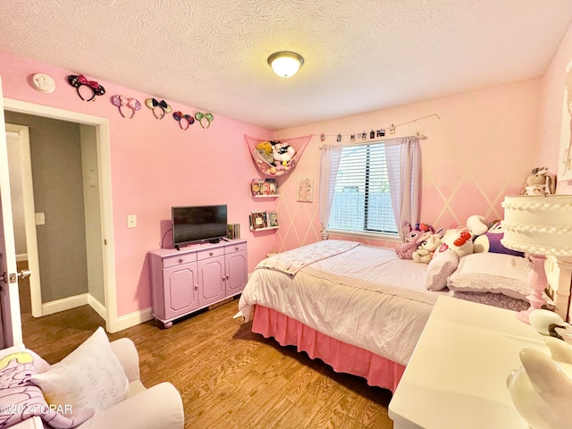 bedroom with a textured ceiling and light wood-type flooring