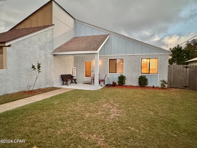 rear view of house featuring a lawn and a patio area