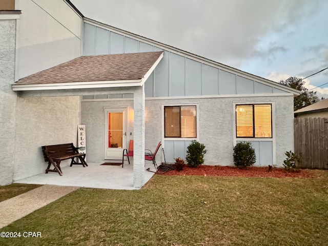 rear view of property with a patio area and a lawn