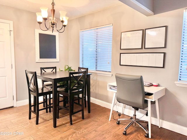 dining space with light hardwood / wood-style floors and a chandelier