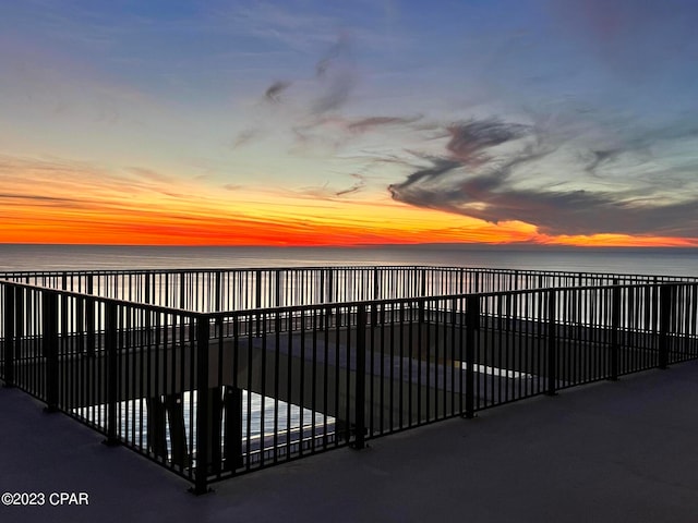 gate at dusk featuring a water view