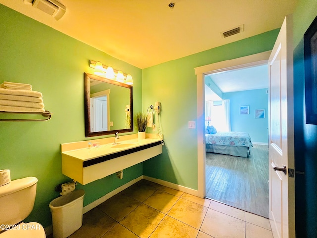 bathroom featuring wood-type flooring, sink, and toilet