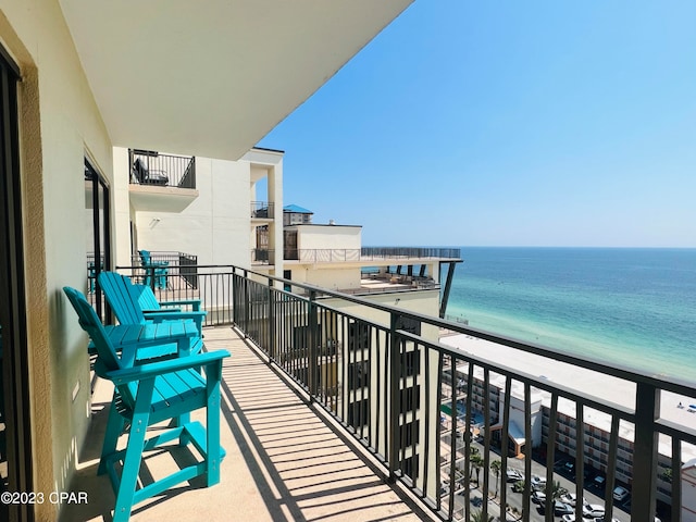 balcony with a water view and a beach view