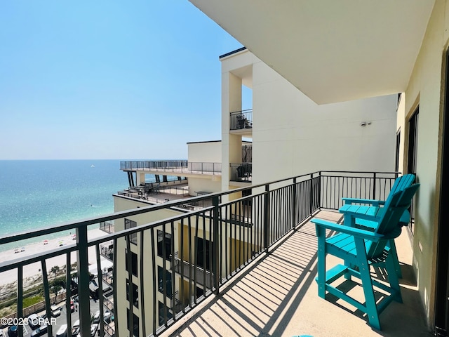 balcony with a water view and a view of the beach