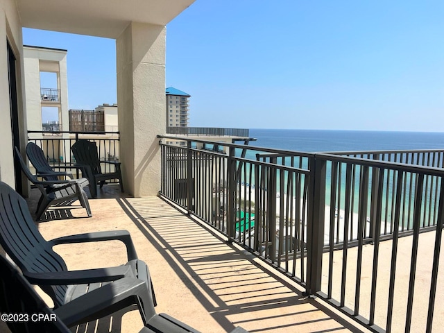 balcony featuring a water view and a beach view