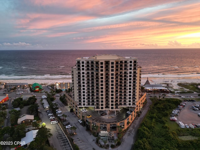 aerial view at dusk featuring a water view