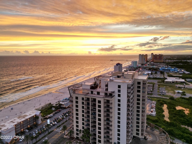 aerial view at dusk featuring a beach view and a water view